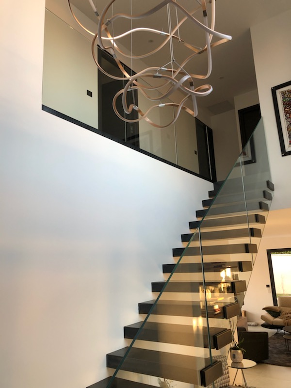 escalier suspendu design acier poli et garde corps en verre